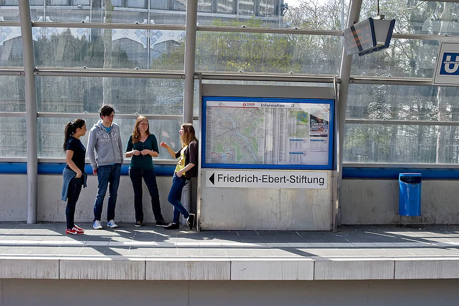 Young students are talking at the railway station.