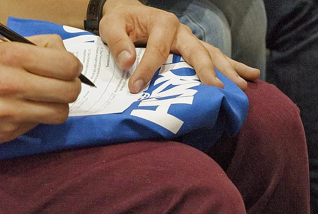 Person signing a blue FES bag